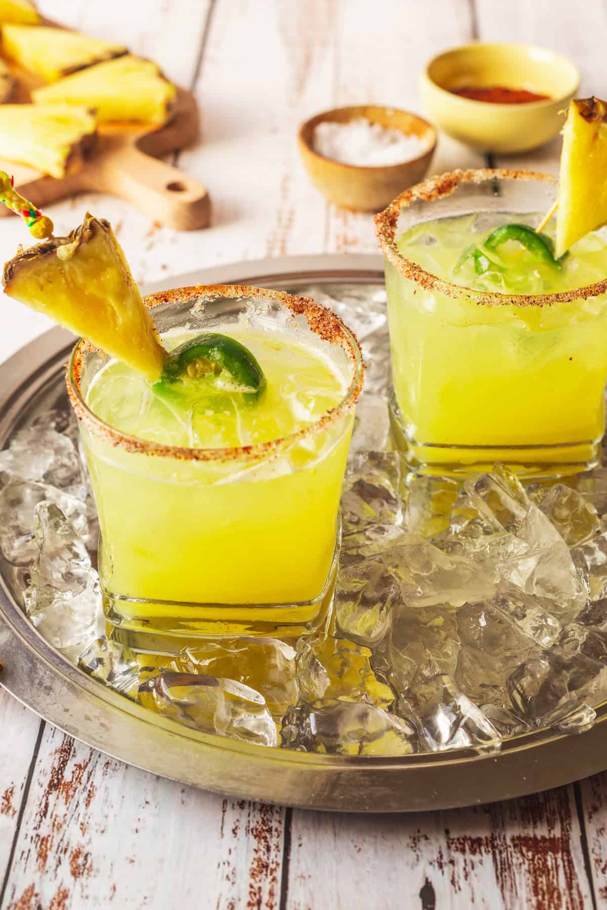 Two glasses of pineapple margarita on a tray.