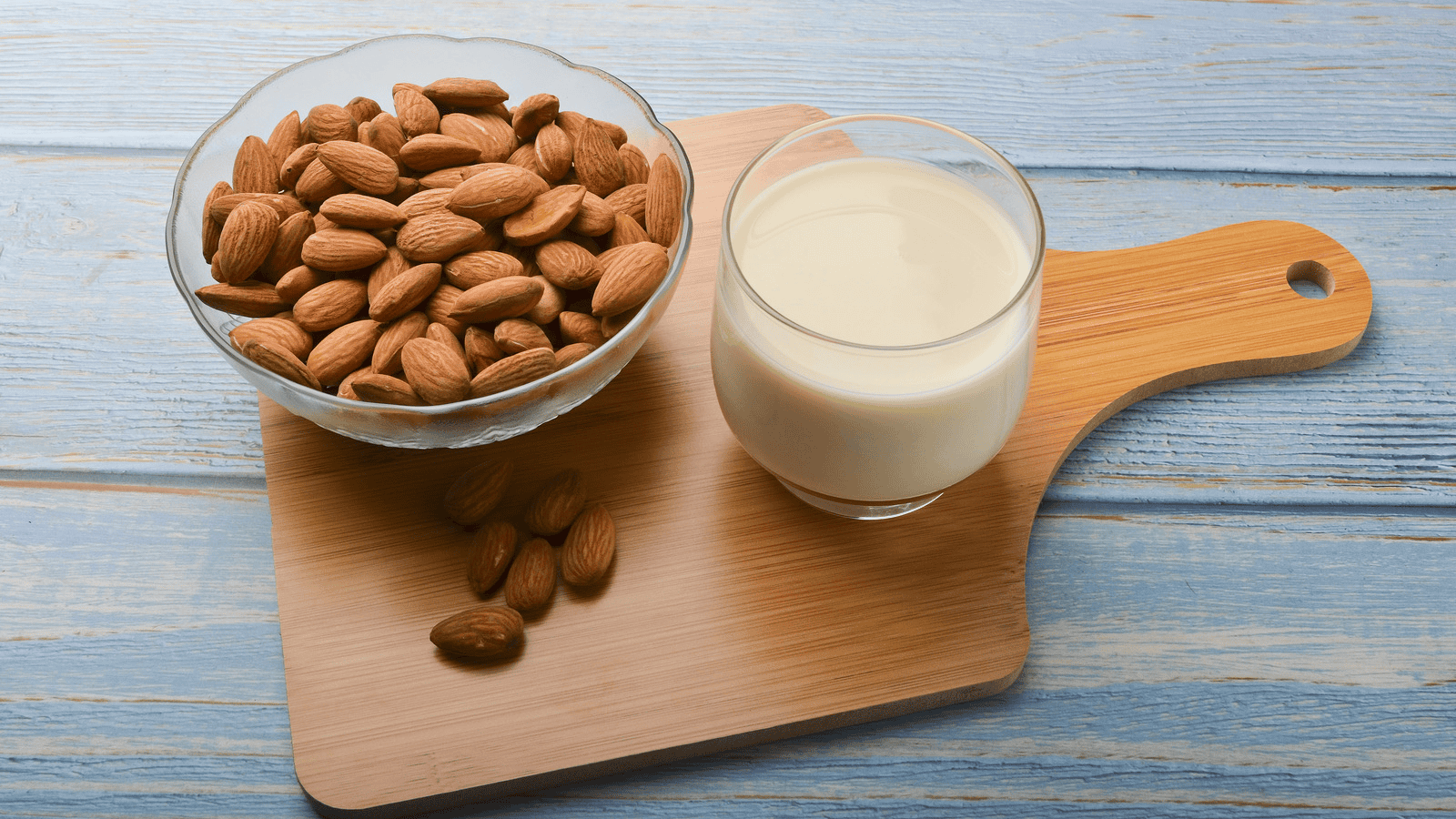 Almond milk with almonds in the background