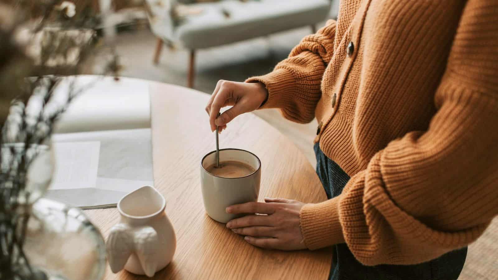 Person stirring a cup of decaffeinated coffee