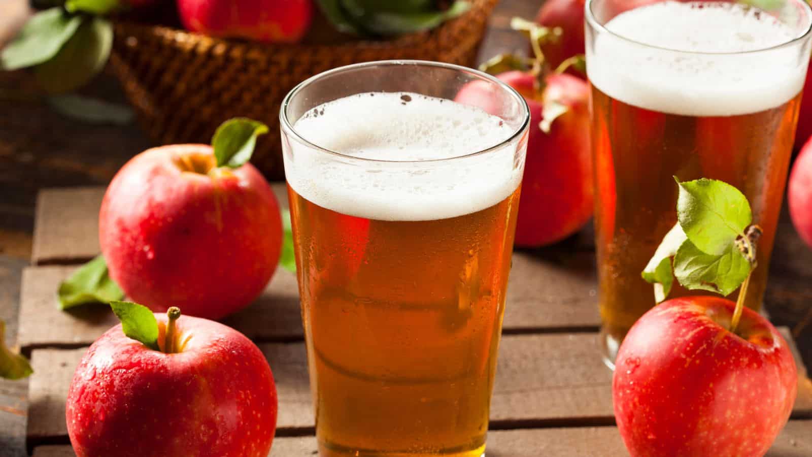 Two glasses of cider surrounded by apples