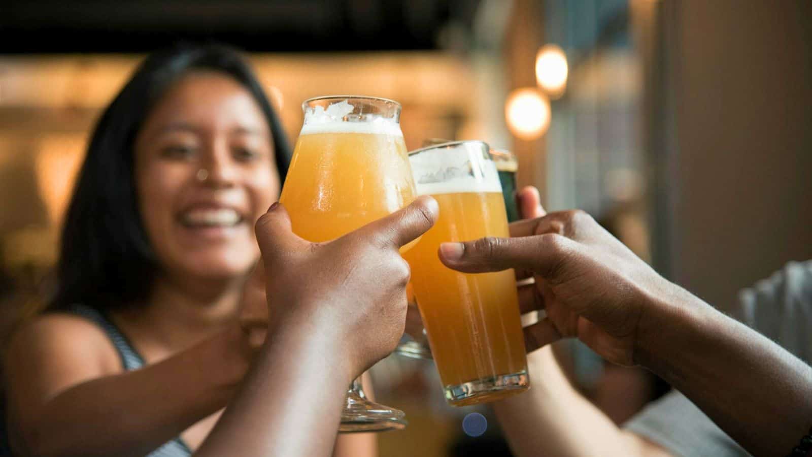 People clinking their glasses of ginger beer together