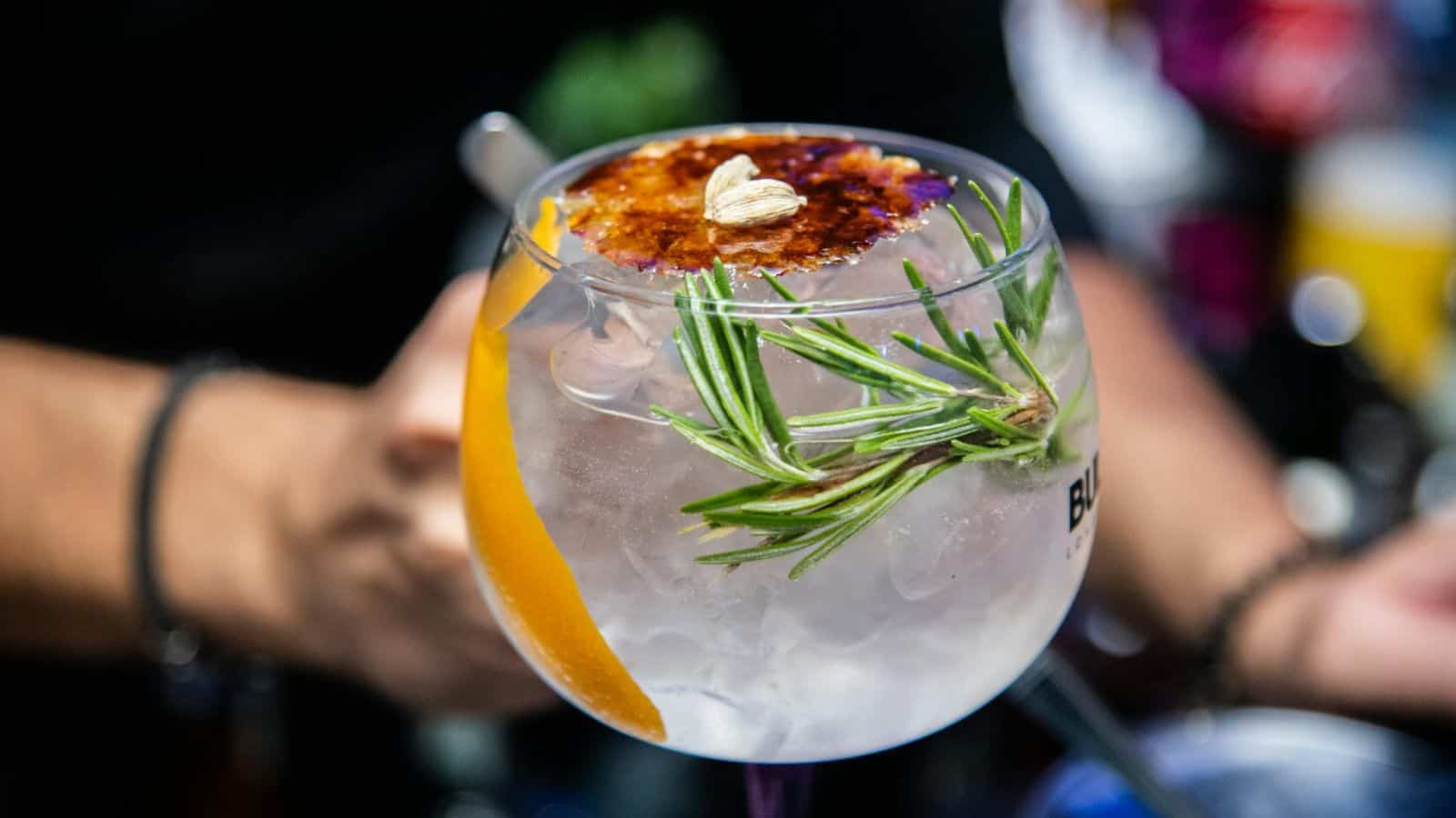 Person holding a small glass of vodka 