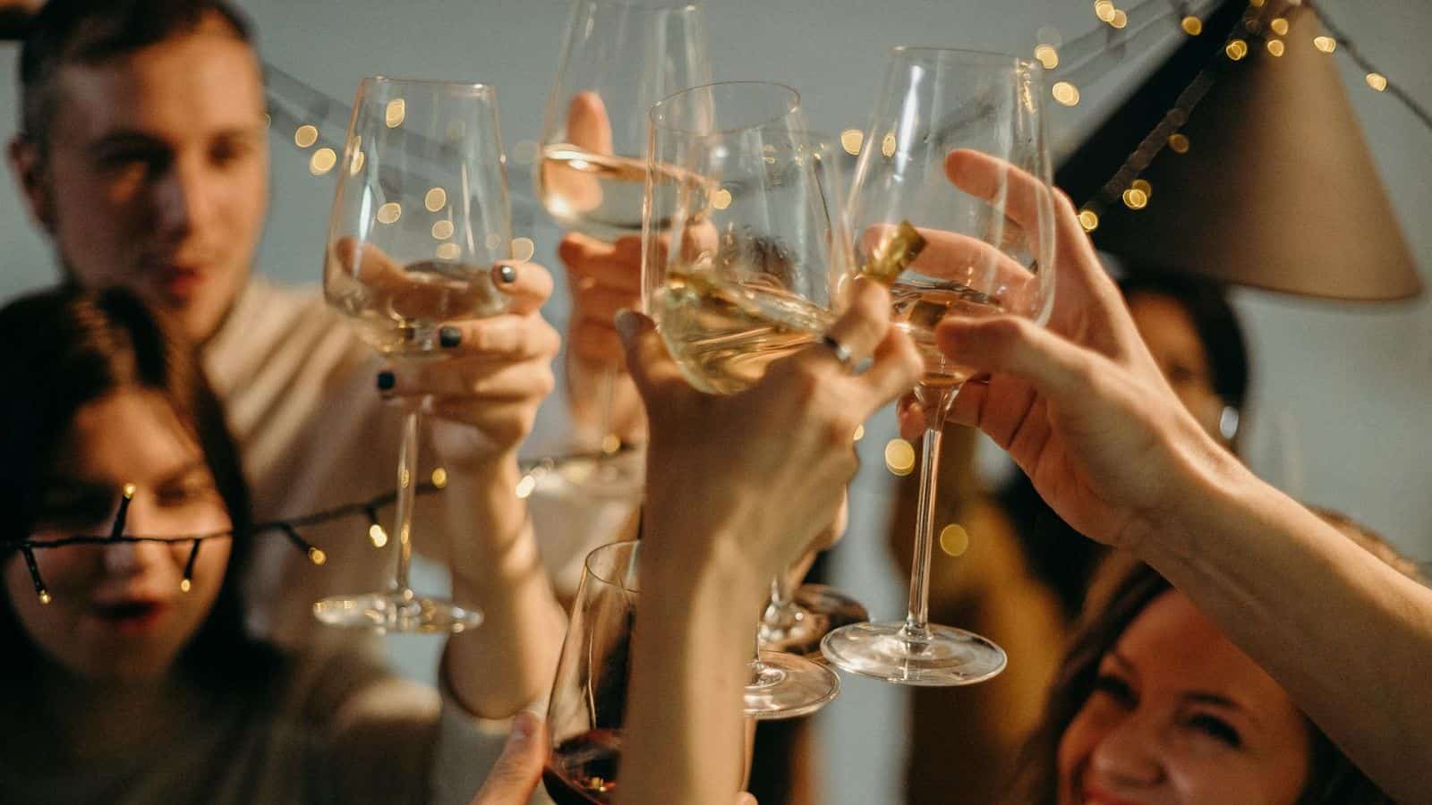 A group of people raising their tall glasses of champagnes for a toast