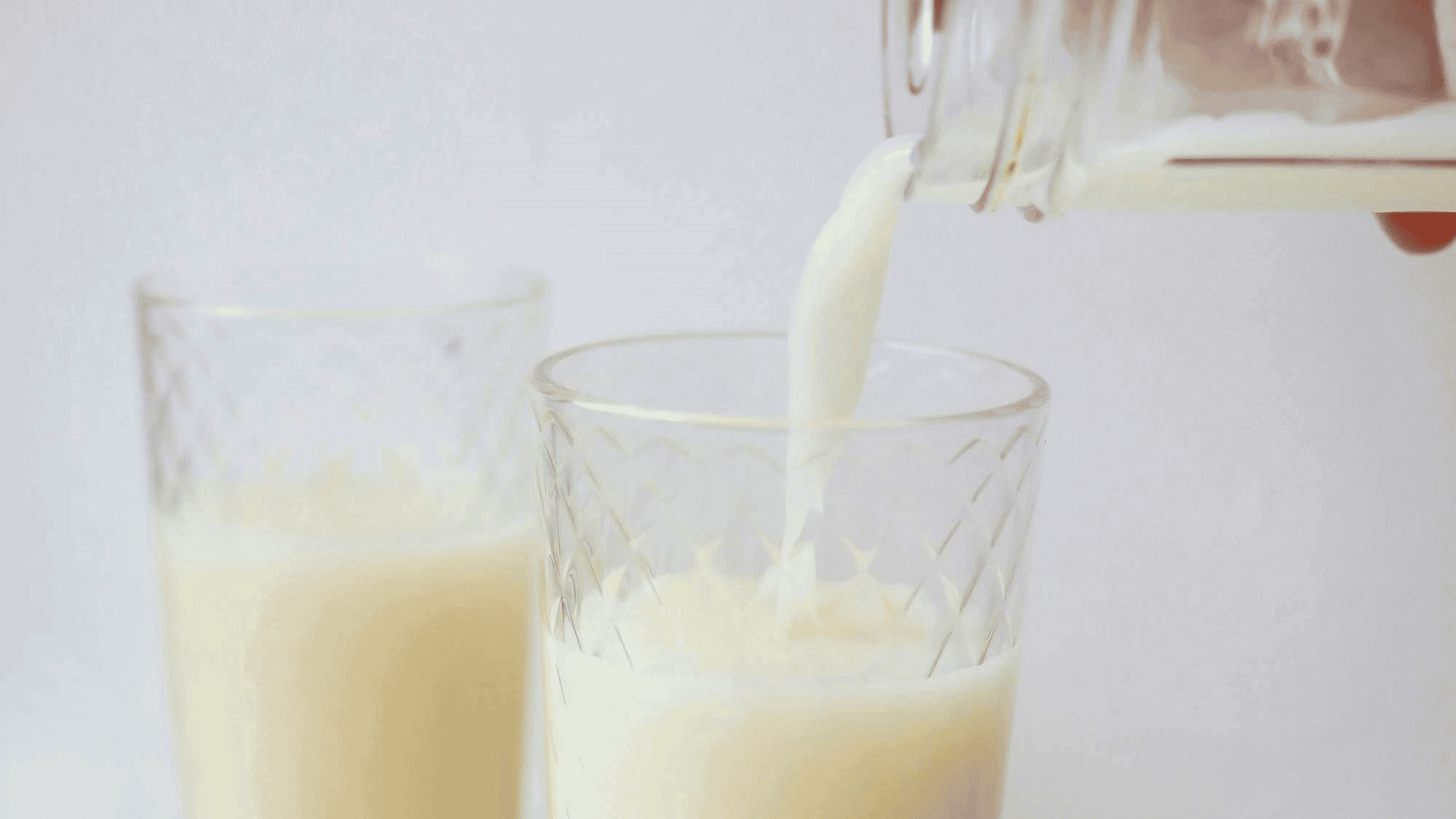 Pouring milk into glasses from bottle