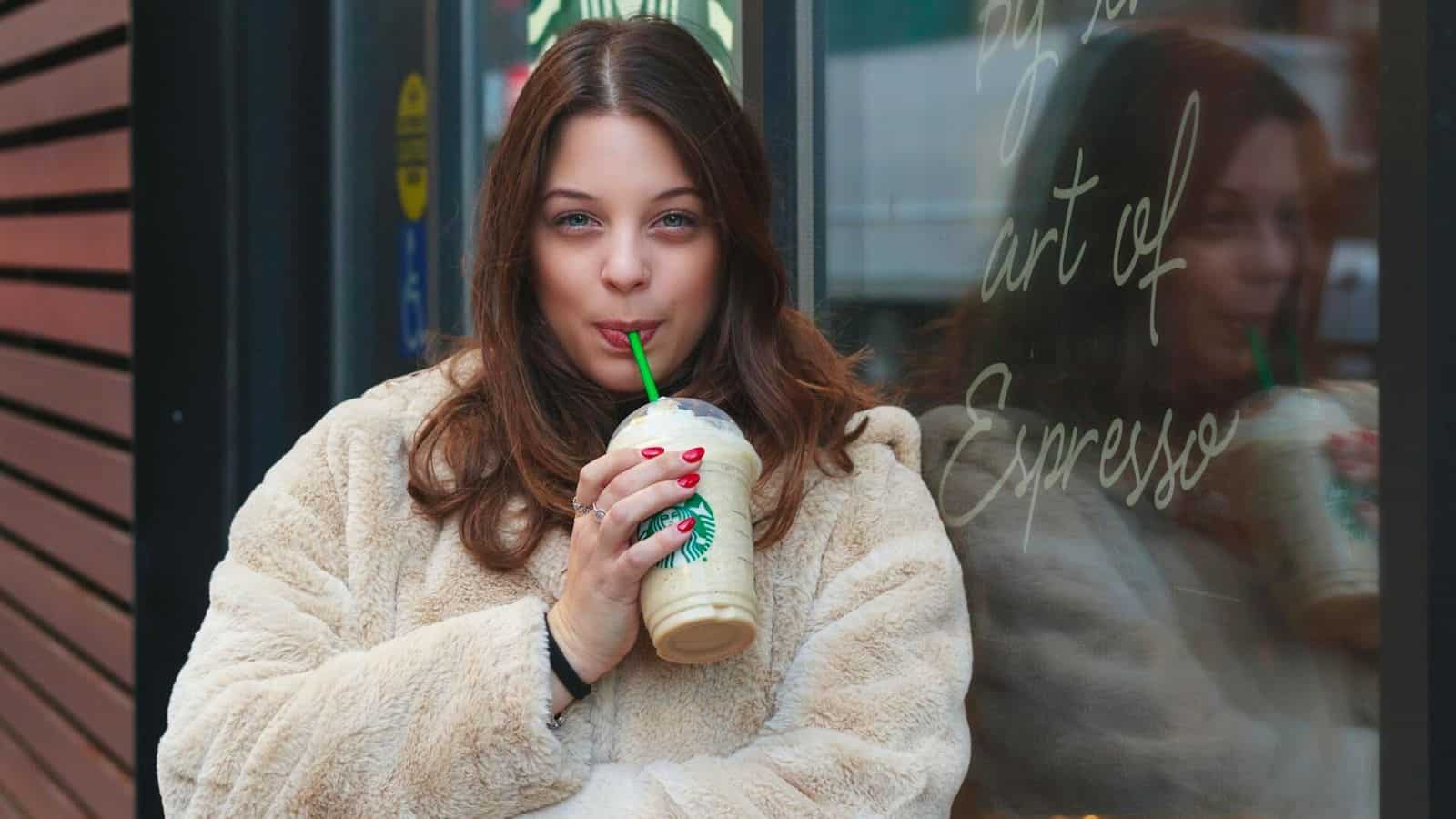Woman drinking from a Starbucks plastic cup