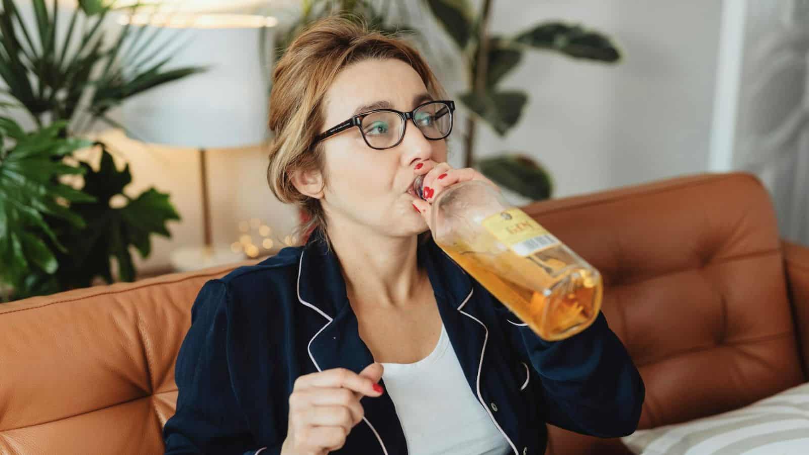 Woman drinking straight from a bottle of alcohol