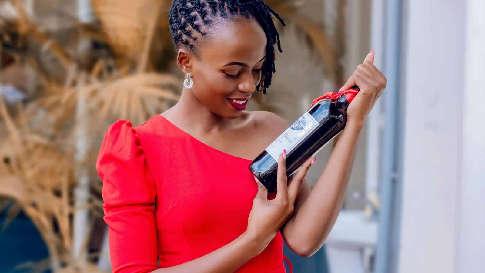 A woman looking at a bottle of red wine