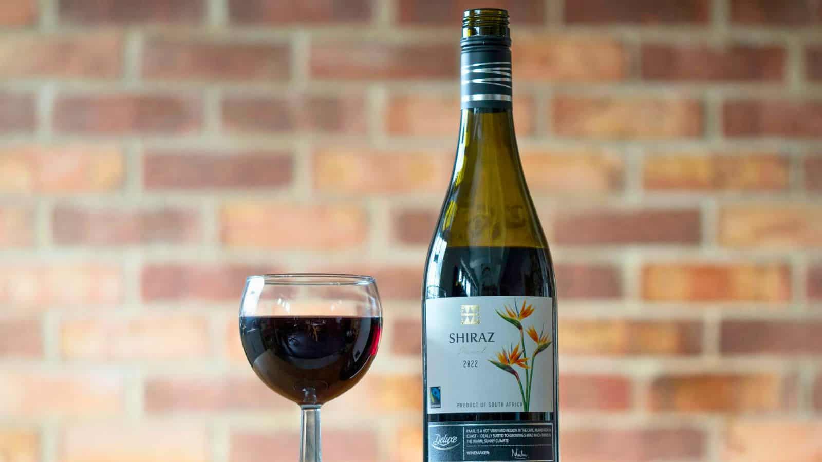 Bottle of Syrah/Shiraz wine and a glass beside it