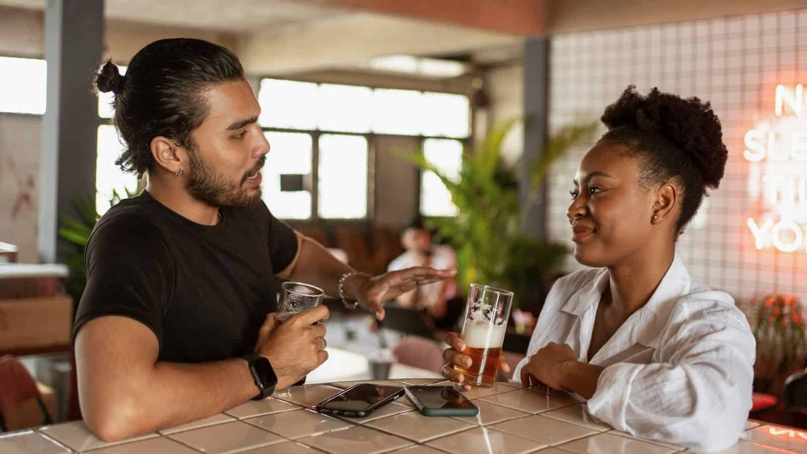 Man and a woman hold glasses of beer