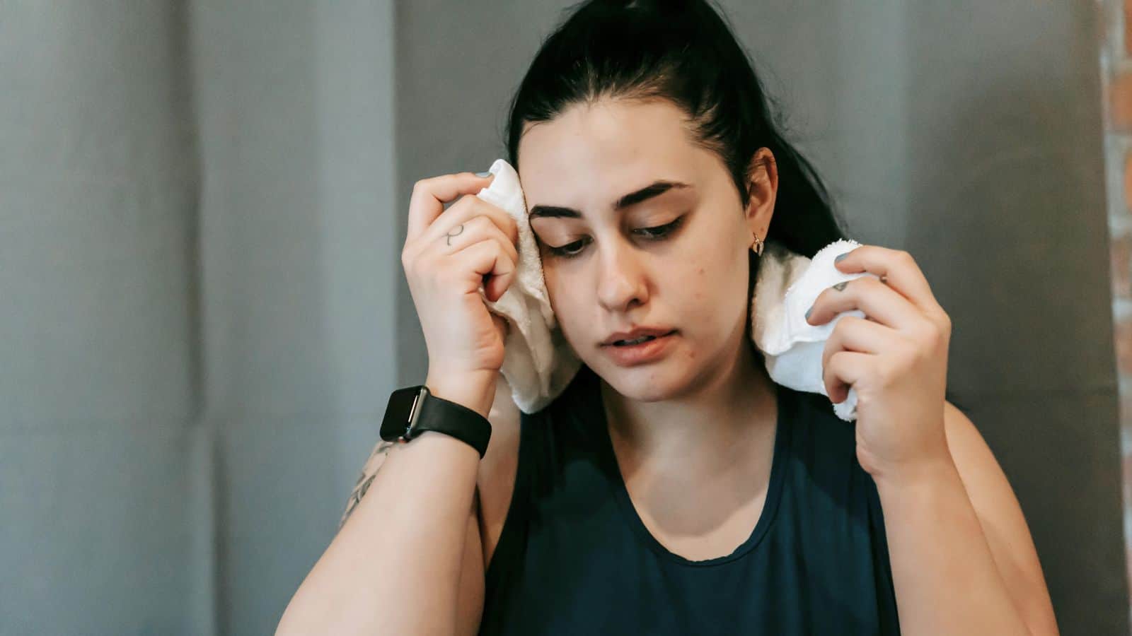 Woman wiping her sweat using a towel
