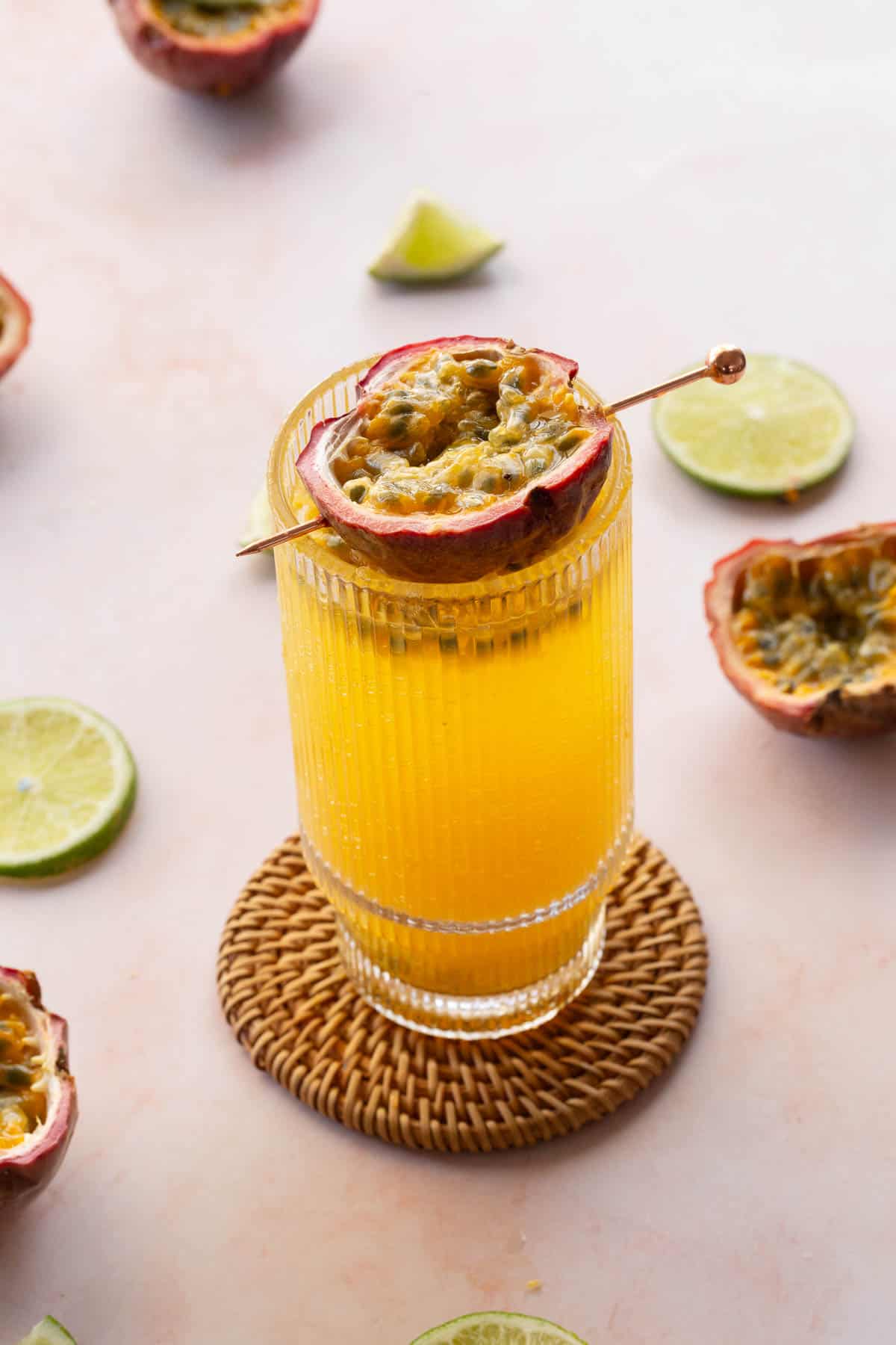 Side view of passionfruit mocktail with lime wedges around