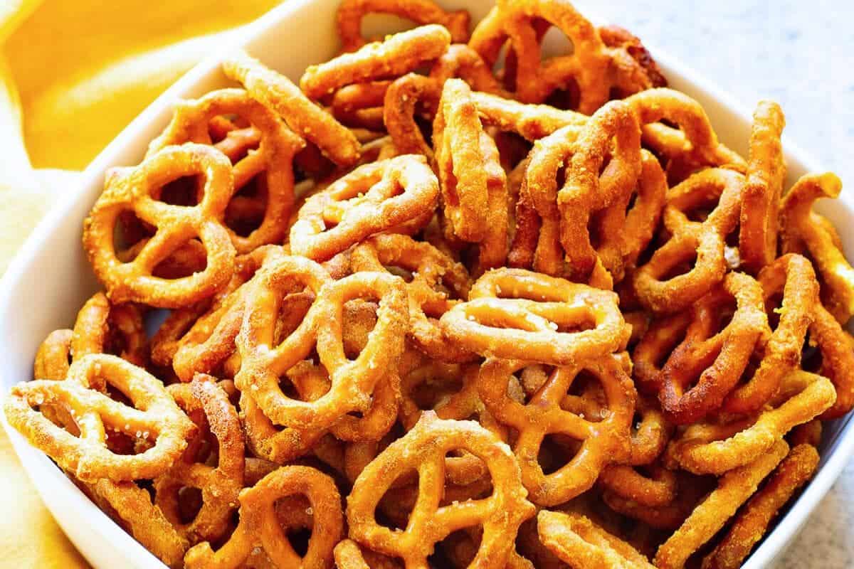 A bowl of Gardetto's mustard pretzels with a light golden color.