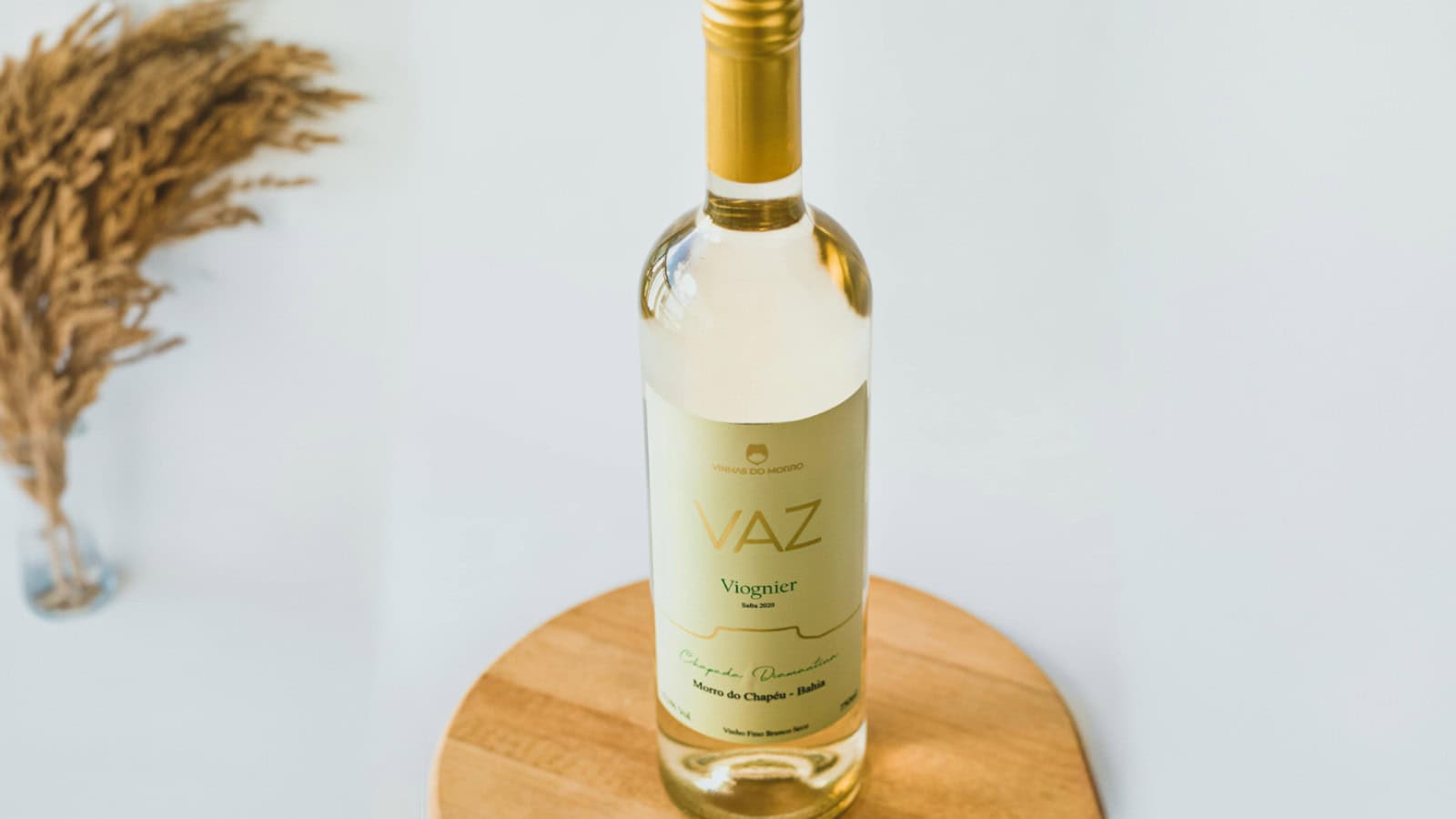 A glass of Viognier on a circular wooden coaster.