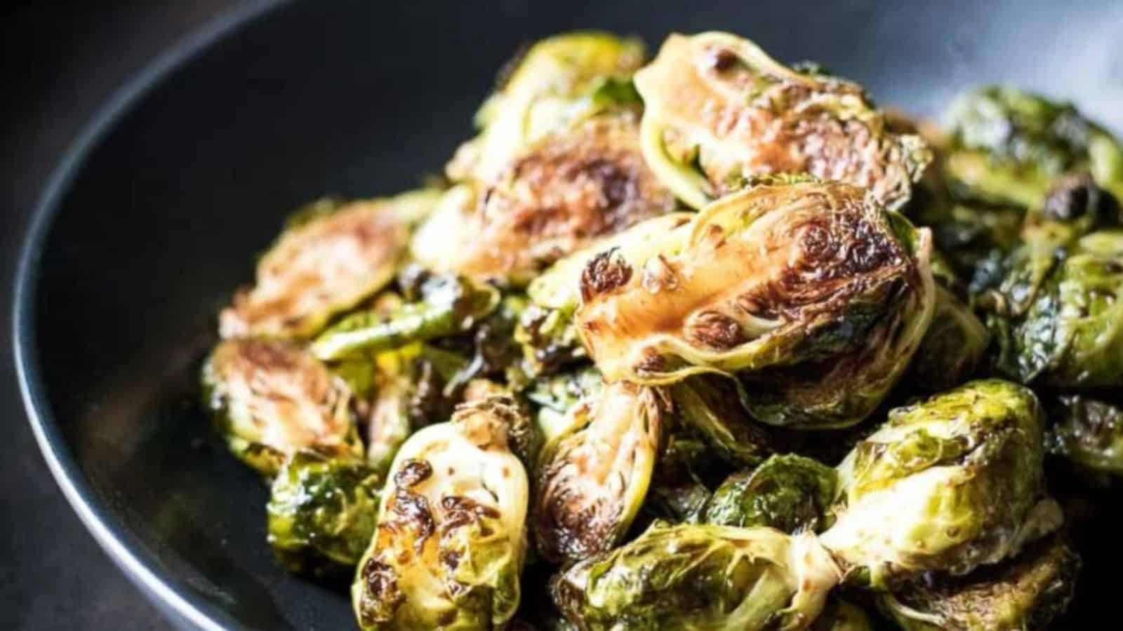 Roasted balsamic glazed brussels sprouts in a black bowl.