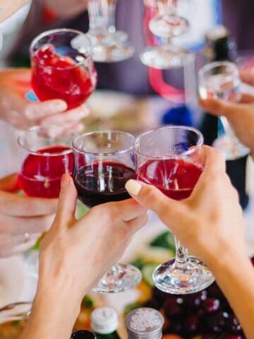 A group of people clinking glasses filled with various beverages during a festive gathering, creating a lively and joyful moment.
