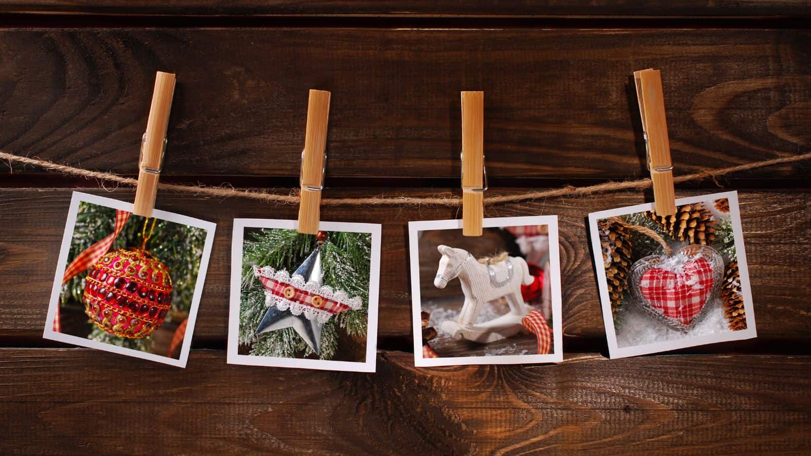 Four Christmas-themed photos hang on a string with clothespins against a wooden background. The images show an ornament, a star decoration, a rocking horse, and a heart-shaped ornament.