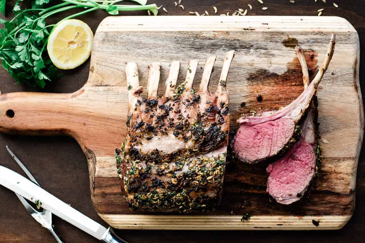 Roasted rack of lamb on a cutting board.