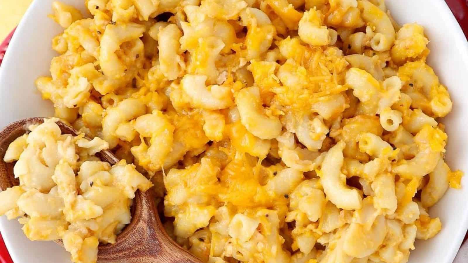 A slow cooker filled with mac and cheese with a gooey, cheesy topping.
