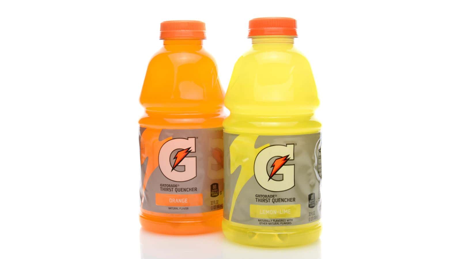 Two bottles of Gatorade Thirst Quencher are shown. The left bottle is orange-flavored with an orange cap, and the right bottle is lemon-lime-flavored with a yellow cap. Both have a Gatorade logo on the label. The background is white.