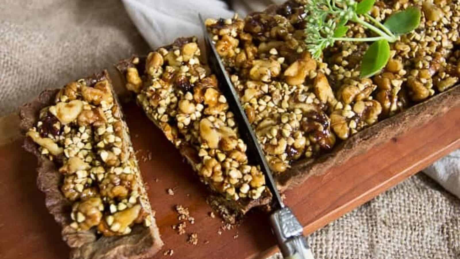 A walnut tart on a wooden cutting board with sprigs of thyme.