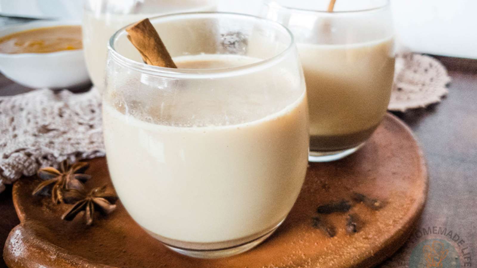 A picture of Pumpkin Pie Spice Latte in glasses with whole cinnamon sticks.