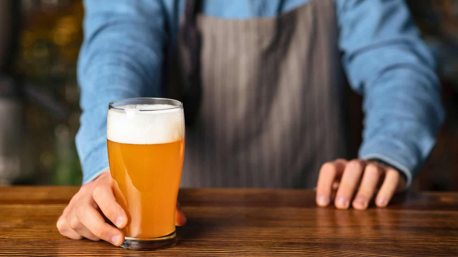 Person holding a glass of ale