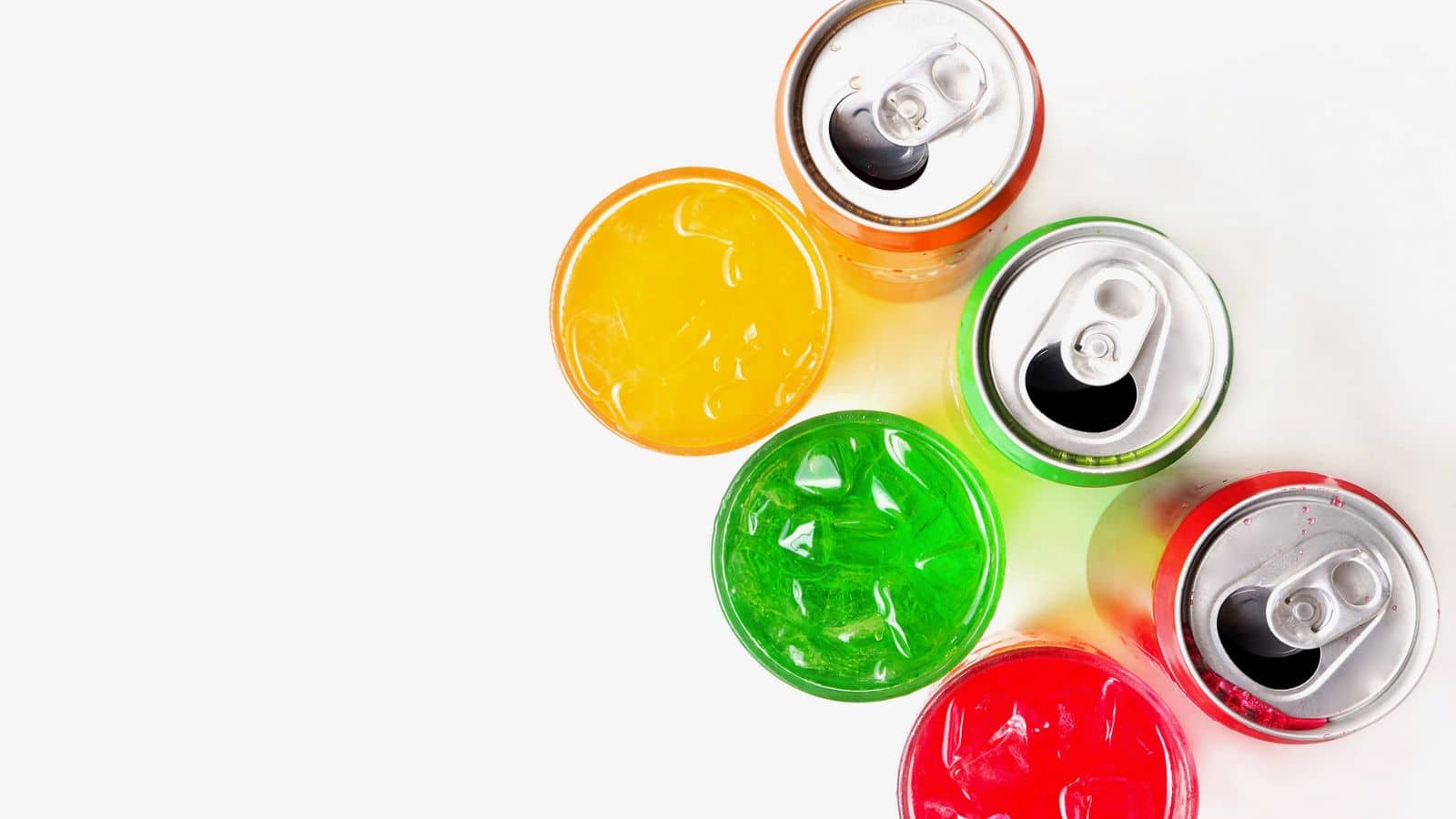Several open soda cans viewed from above are arranged in a semicircle. The cans contain different colored sodas: orange, green, and red, each with ice cubes visible inside. The background is white.