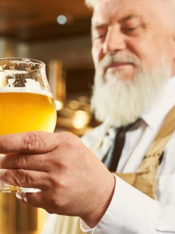 Old man looking at a glass of ale
