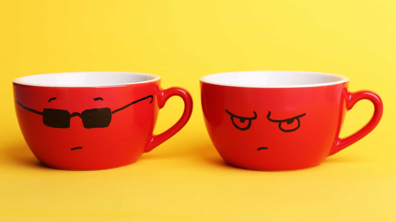 Two red mugs against a yellow background. The mug on the left has a face with sunglasses and a neutral expression, while the mug on the right has a face with an angry expression.