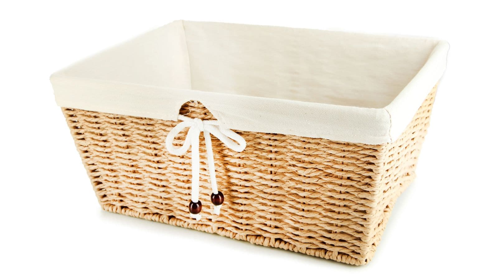 A rectangular wicker basket with a white fabric lining and a decorative white bow with beads on one side. The basket is empty and placed against a plain white background.