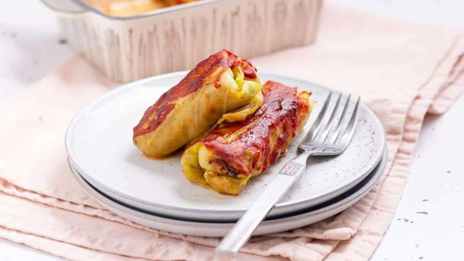 Two cabbage rolls on a plate with fork.