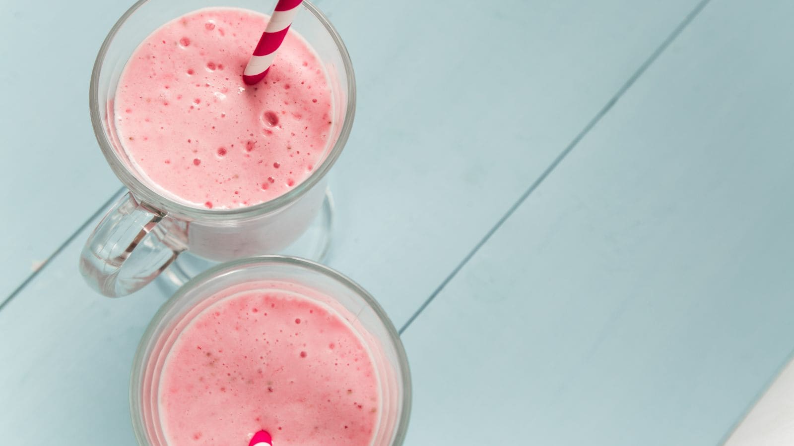 Two glasses of strawberry milkshakes.