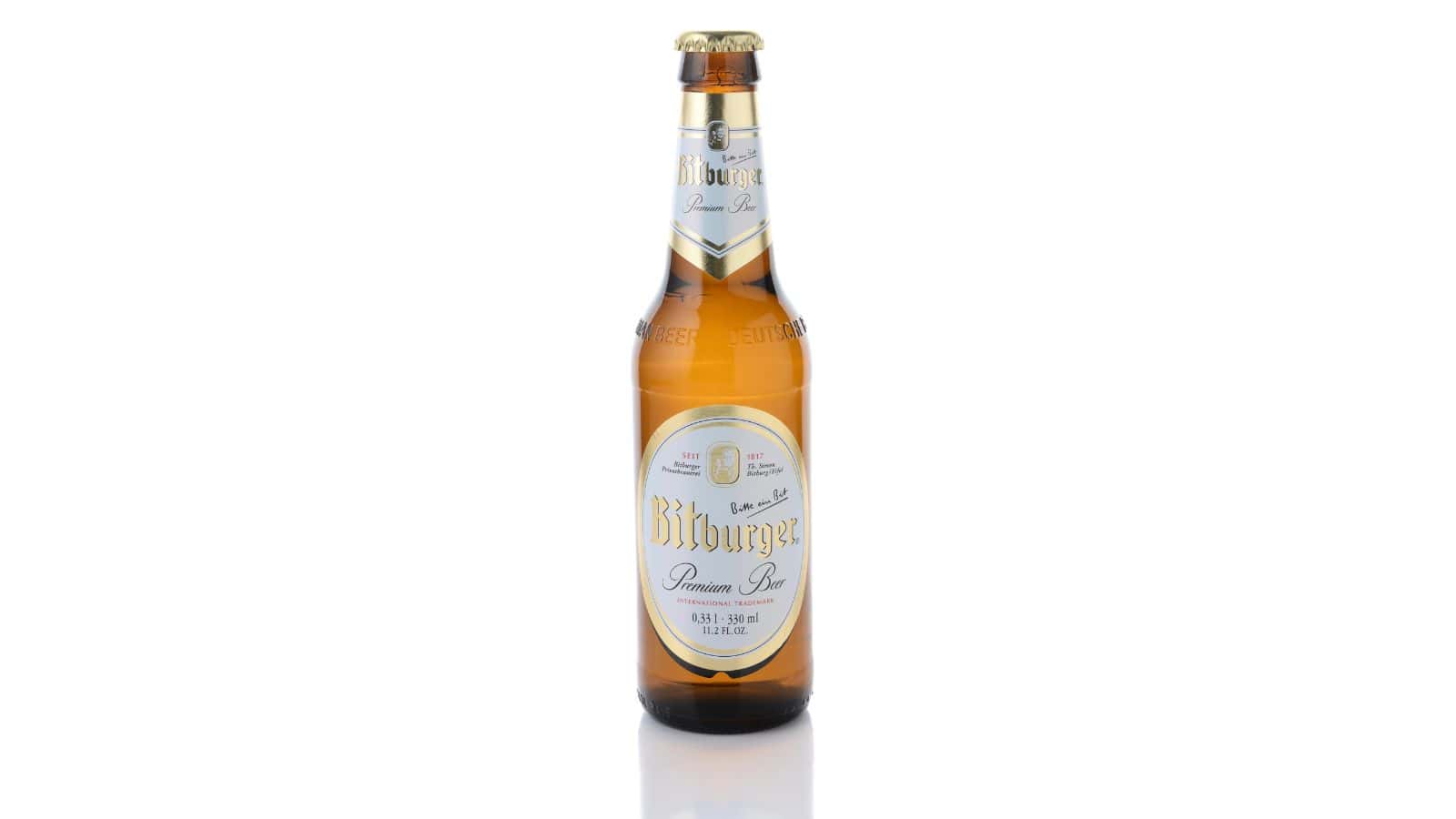 A single bottle of Bitburger Premium Pils stands upright against a white background. The bottle is amber-colored with a gold and white label, displaying the brand name and beer details. The cap is gold.