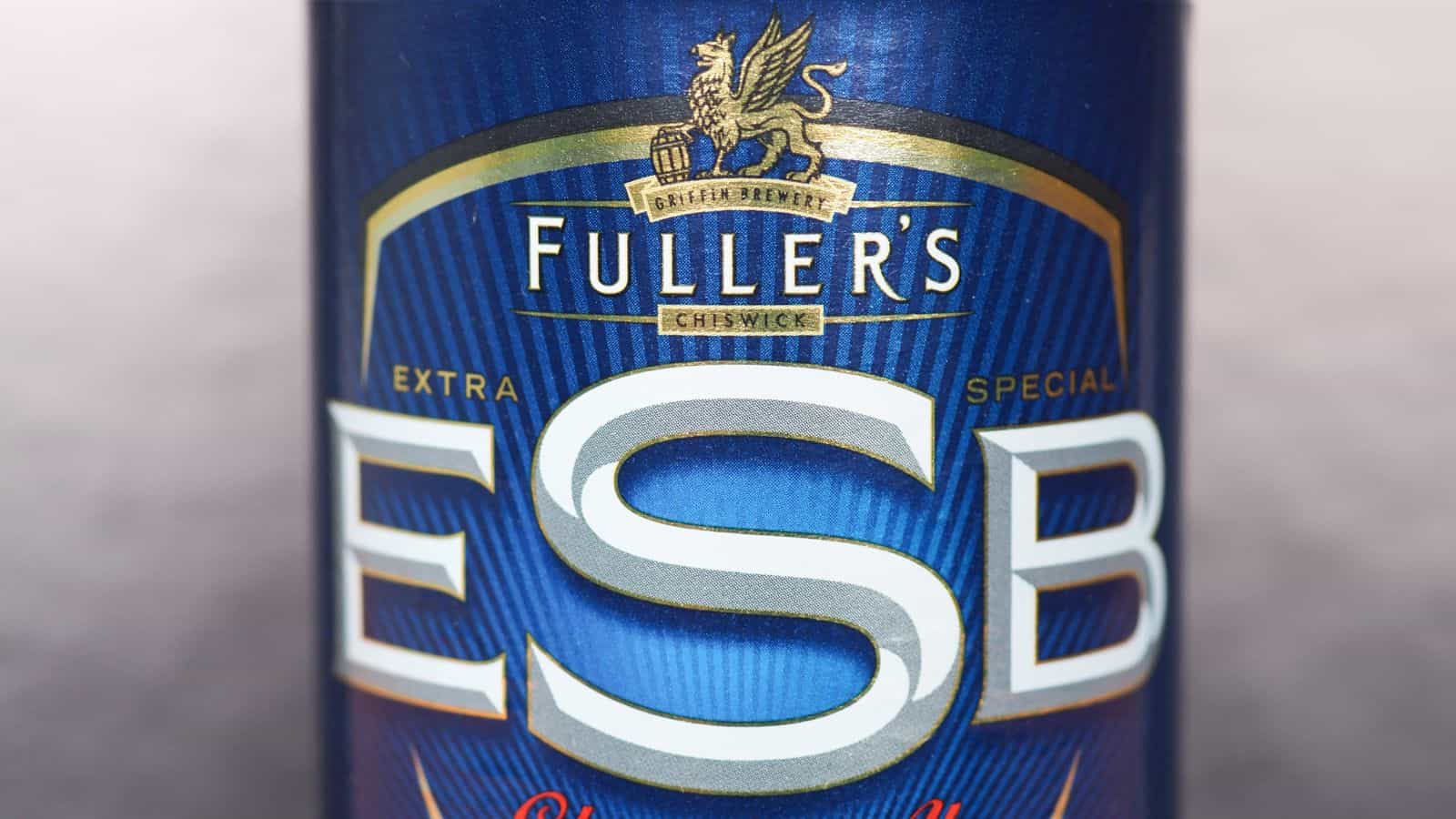 Close-up of a Fuller's ESB beer can. The design features a blue background with a gold, stylized griffin emblem above the words "Fuller's Chiswick" and "Extra Special Bitter" in large letters.