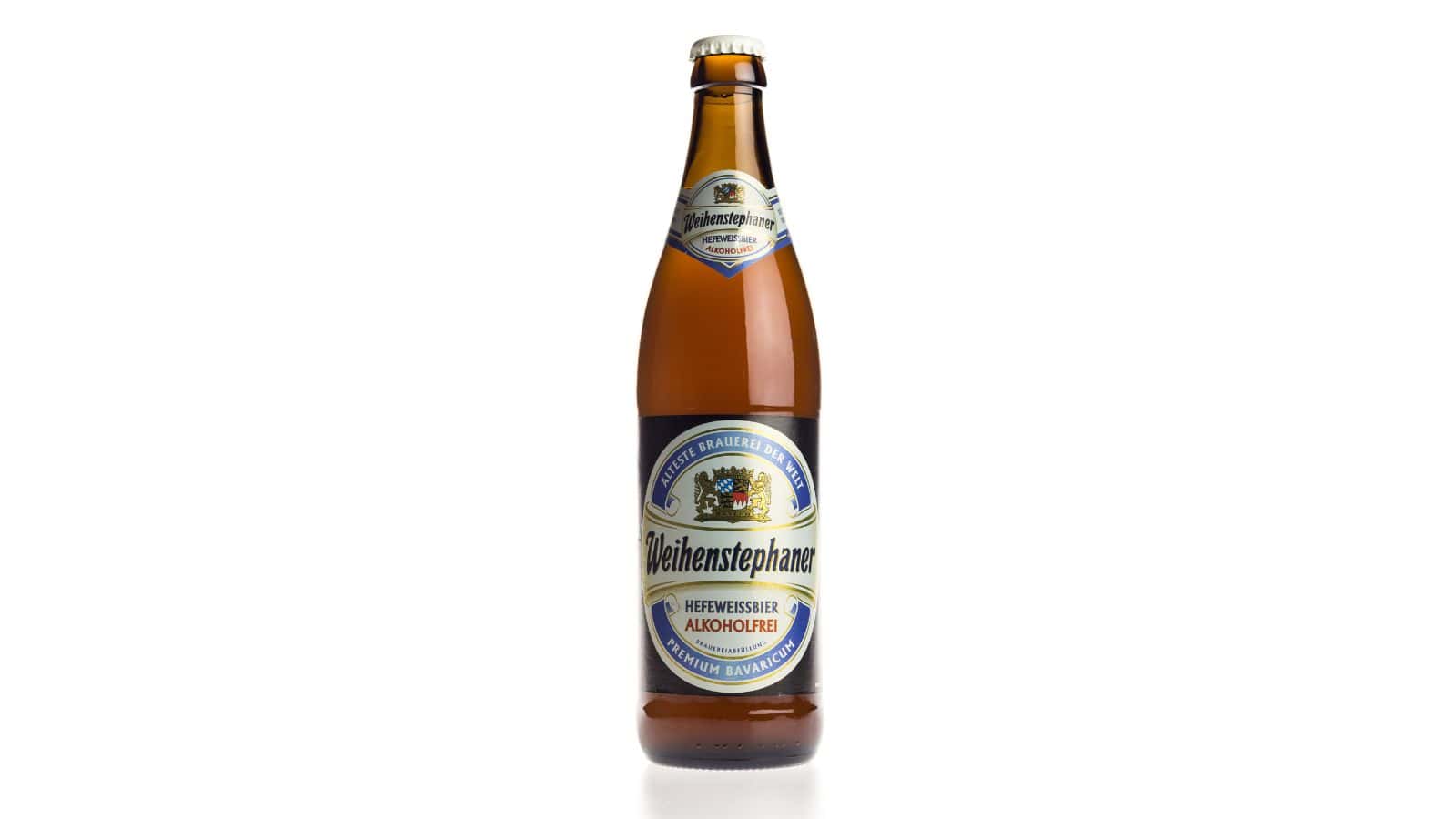A brown glass bottle of Weihenstephaner Hefeweissbier Alkoholfrei beer. The label features blue and gold accents with a crest. The bottle has a gold cap and is placed against a plain white background.