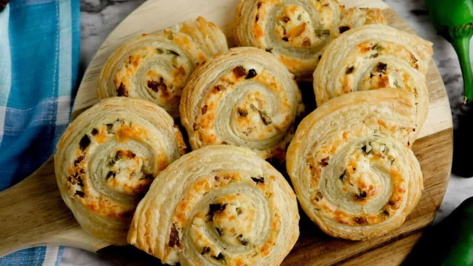 Puff pastry pinwheels on a round wooden cutting board.