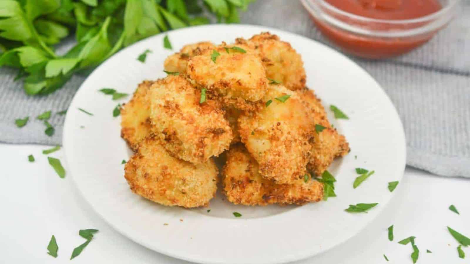 Air fryer chicken nuggets on plate with ketchup.