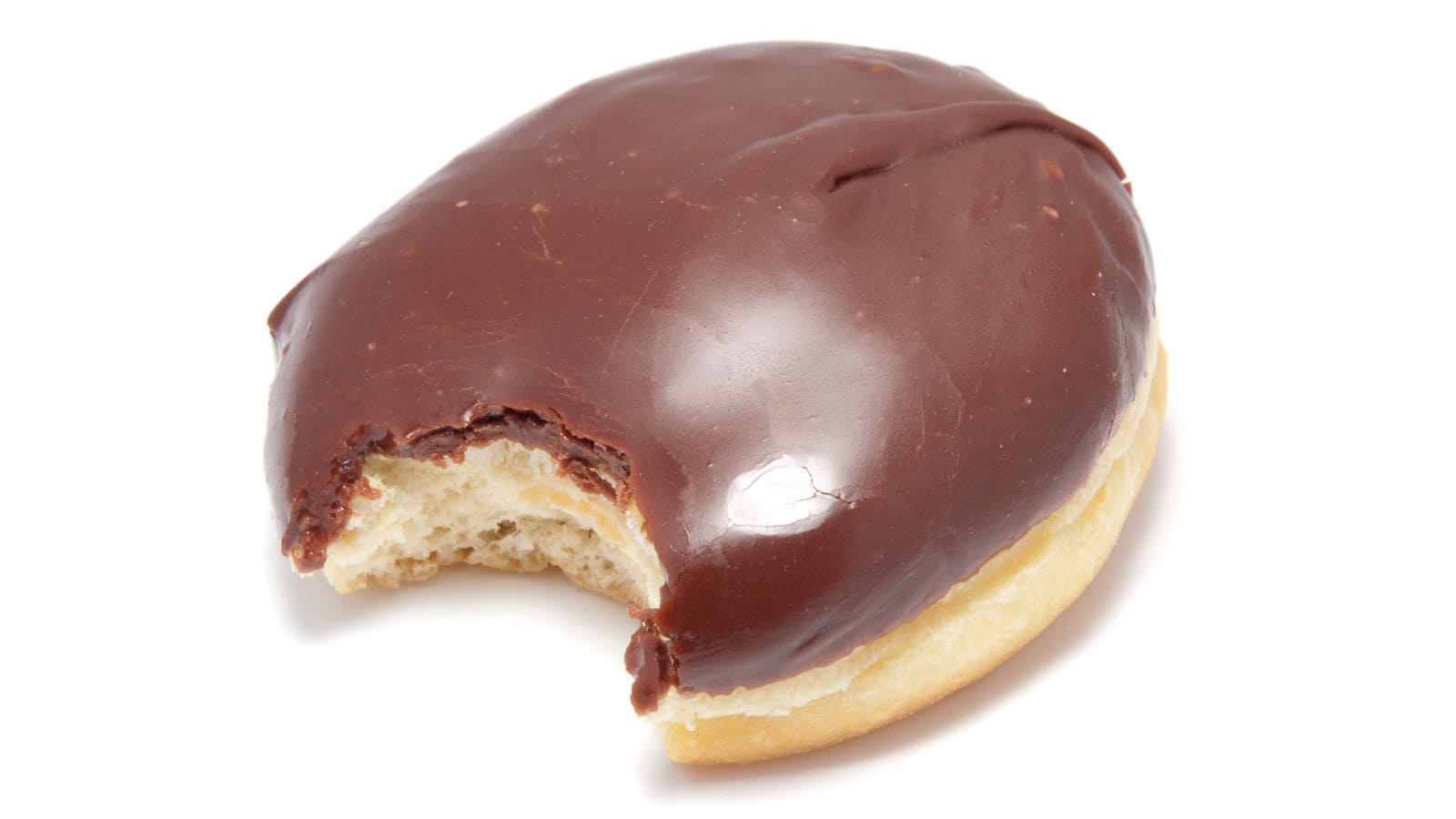 A chocolate-covered donut with a bite taken out, showing the inner pastry. The donut is on a plain white background.