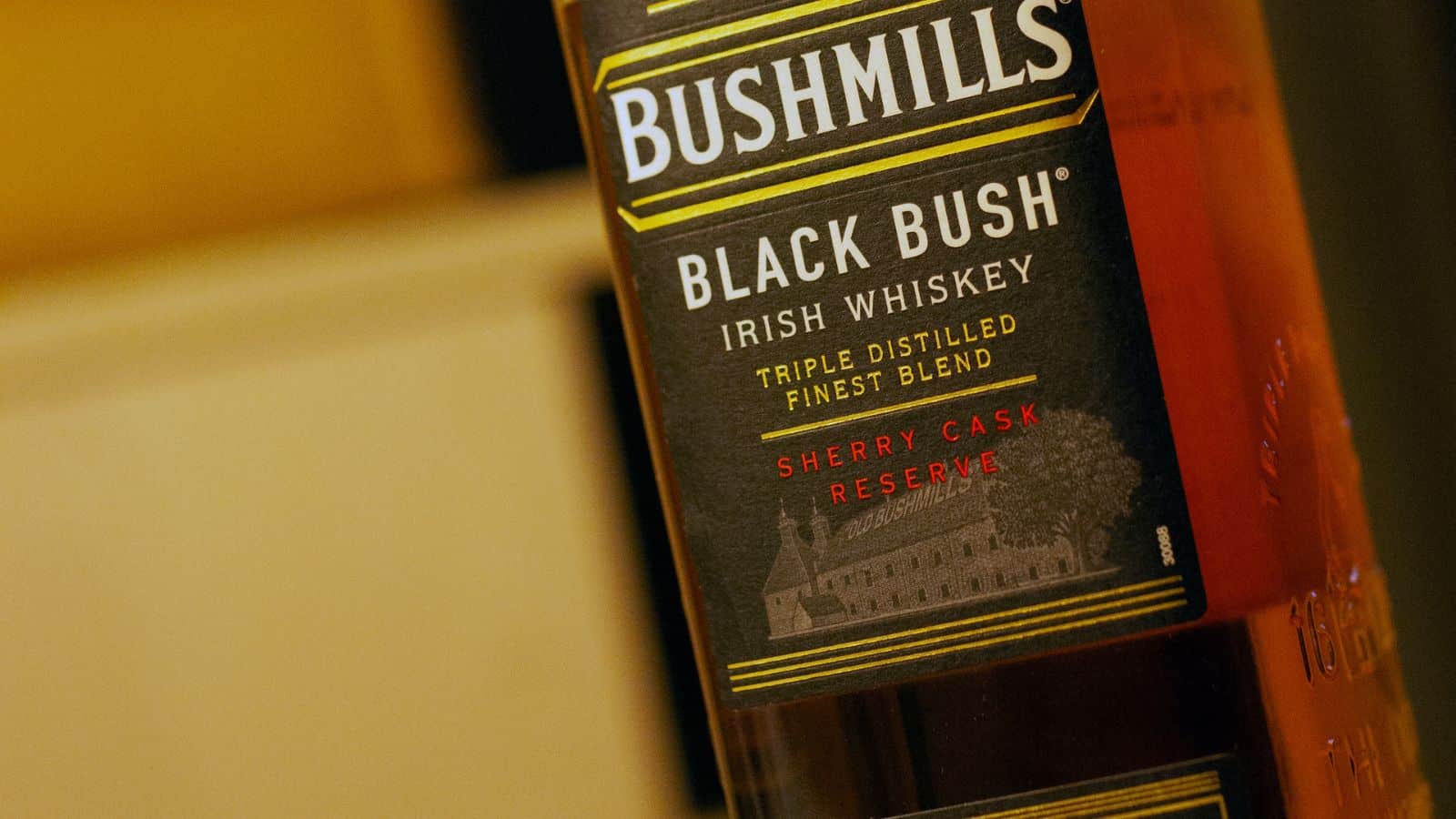 A close-up view of a Bushmills Black Bush Irish Whiskey bottle label, highlighting the text "Triple Distilled Finest Blend" and "Sherry Cask Reserve" in white, gold, and red lettering.