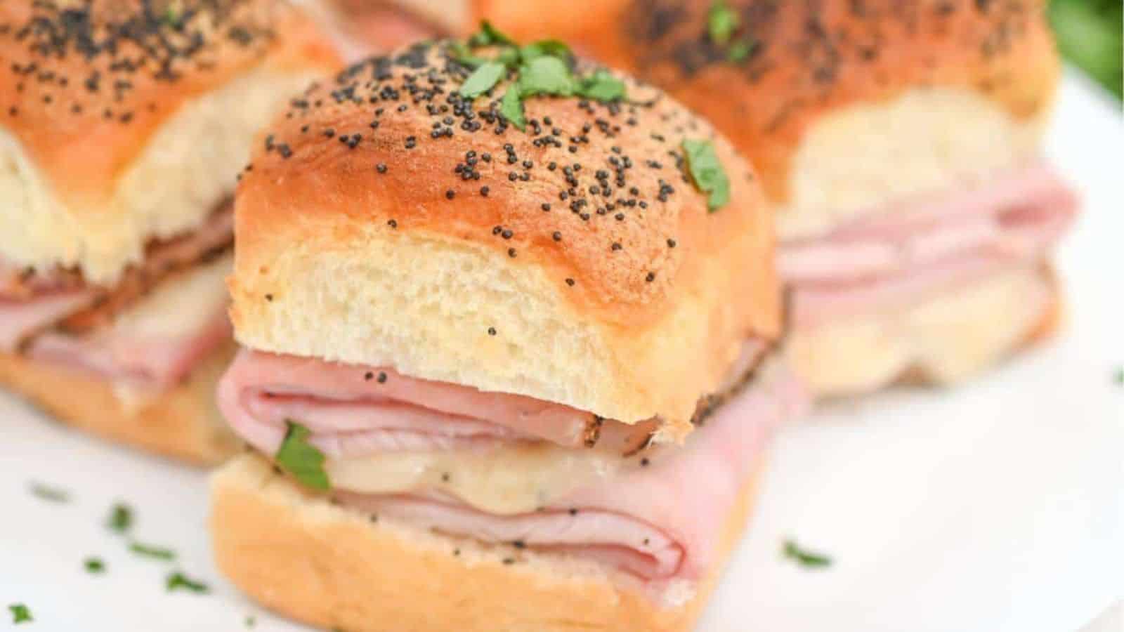 Ham and cheese sliders on a plate.