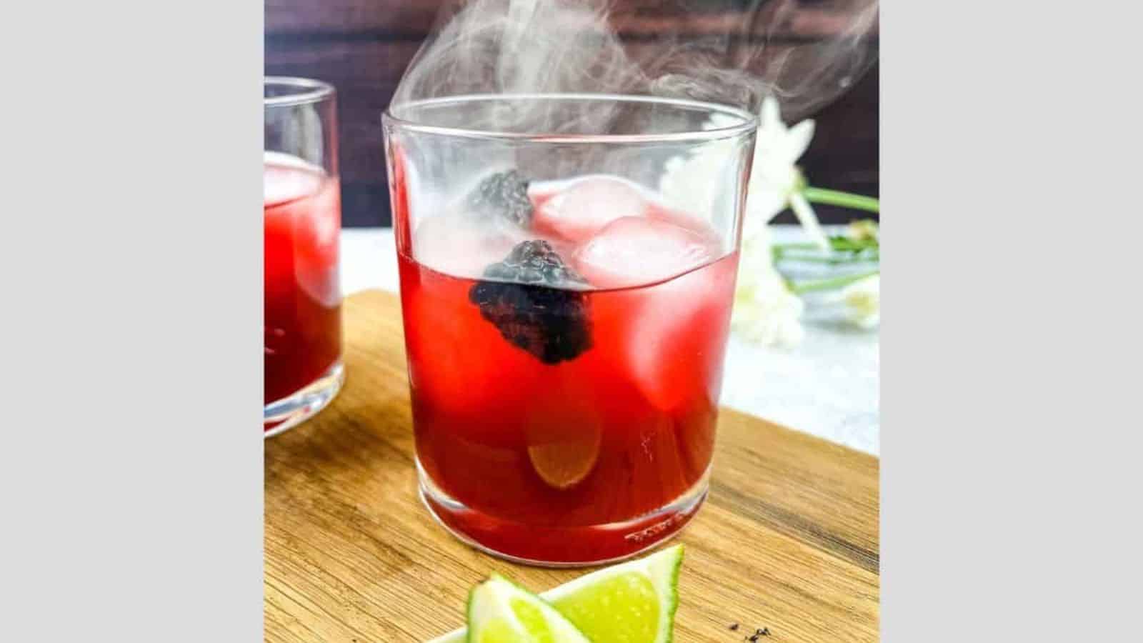 Smoked Blackberry Margarita with smoke coming out the top of the glass.