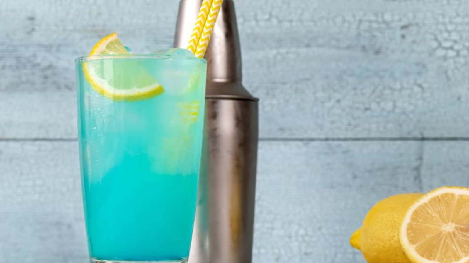 A picture of two glasses of electric lemonade with lemon wedge.