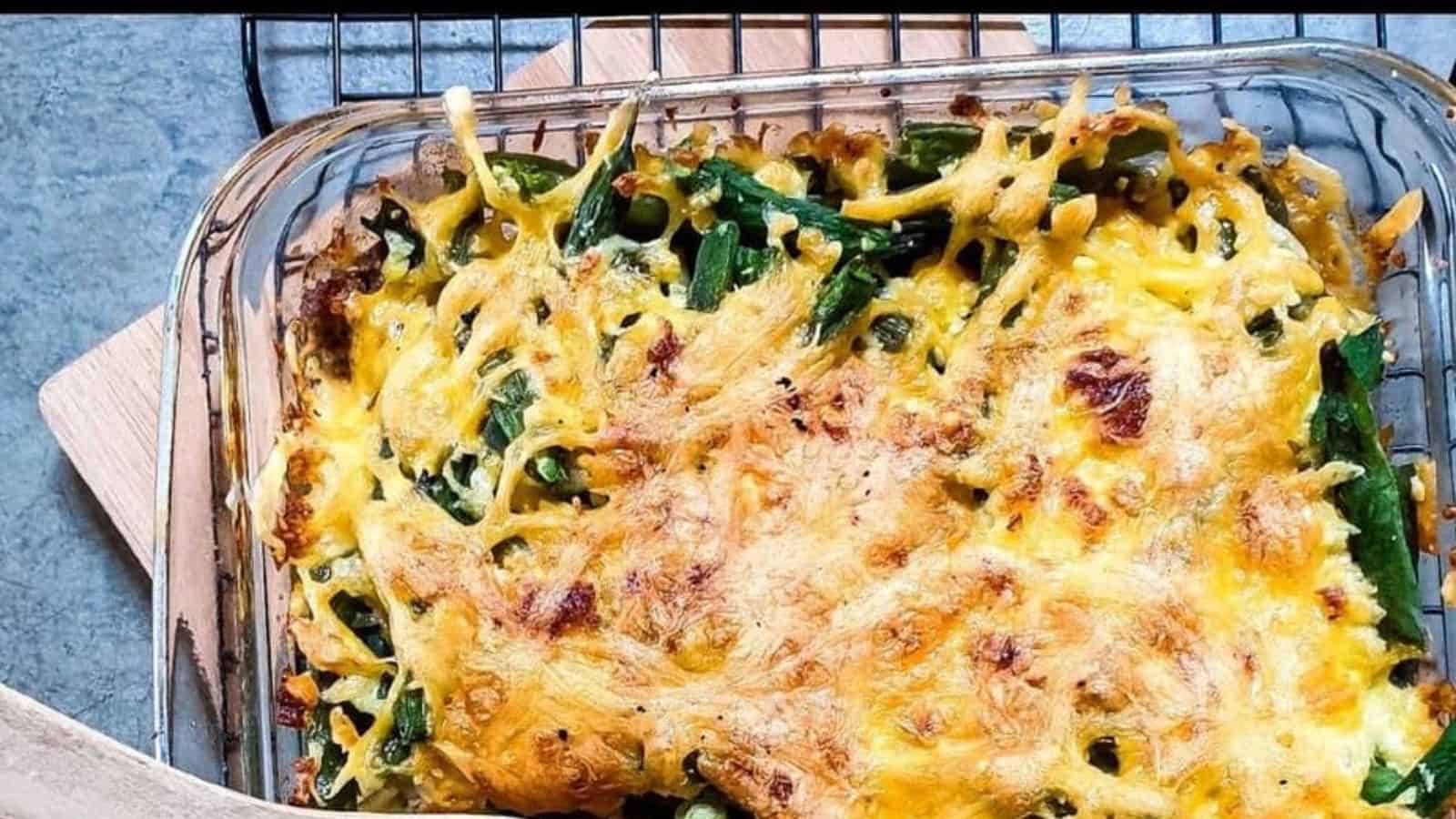 Green bean casserole being served with wooden spoon.