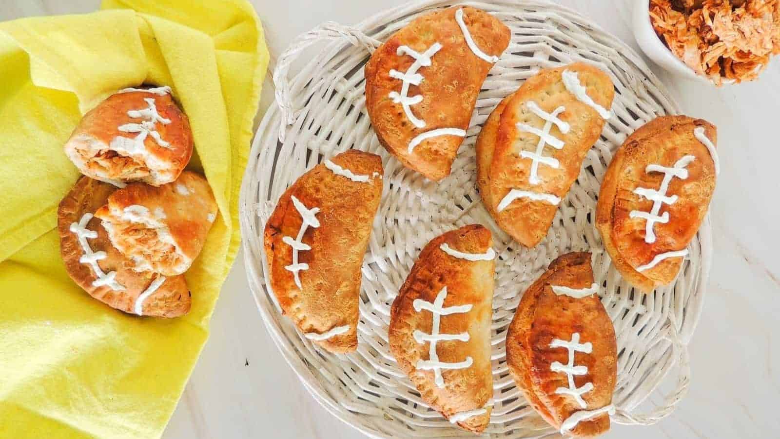 A basket of football shaped buffalo chicken pockets on a table.