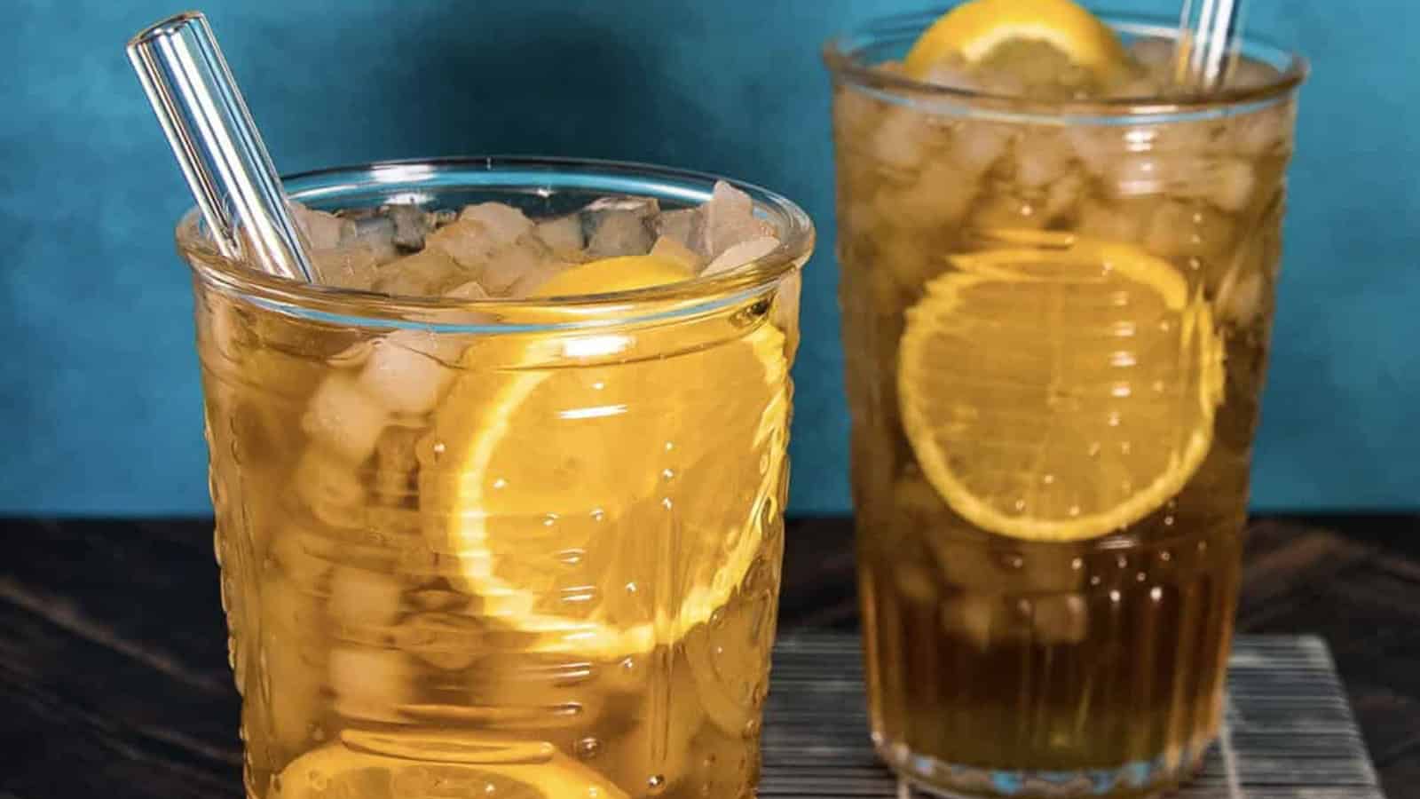 A pair of glasses with ice and lemons.