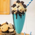 A Cookie Monster Milkshake, this blue milkshake is topped with cookies, whipped cream, mini Oreos, and a striped straw&mdash;a playful treat inspired by everyone&rsquo;s favorite cookie-loving monster.