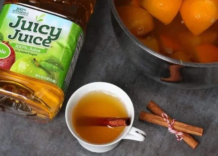 Bottle of juice, cup of apple cider, and pot of apple cider.