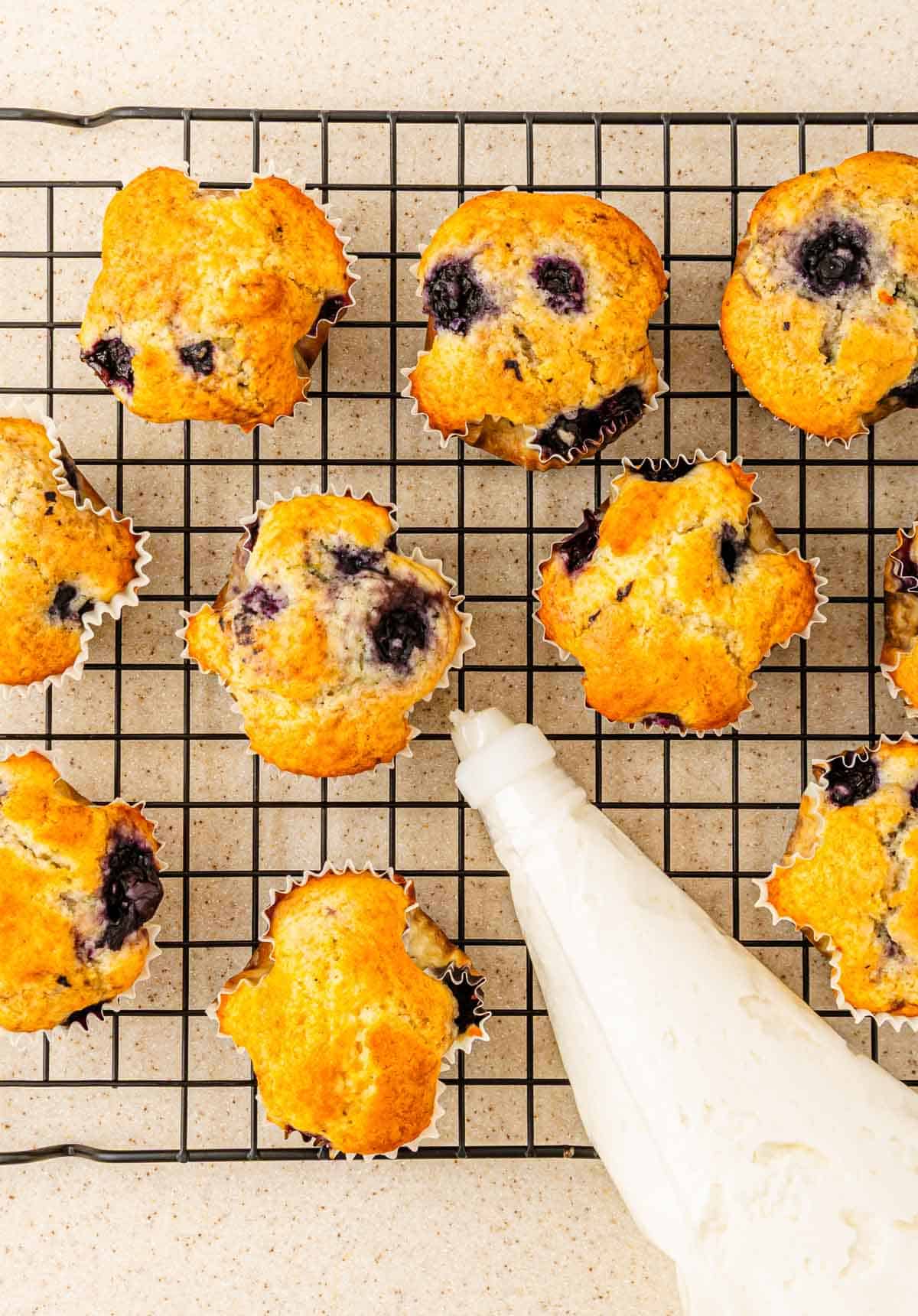 BOO-berry muffins on a cooling rack with a piping bag filled with Scream Cheese Icing on the side.