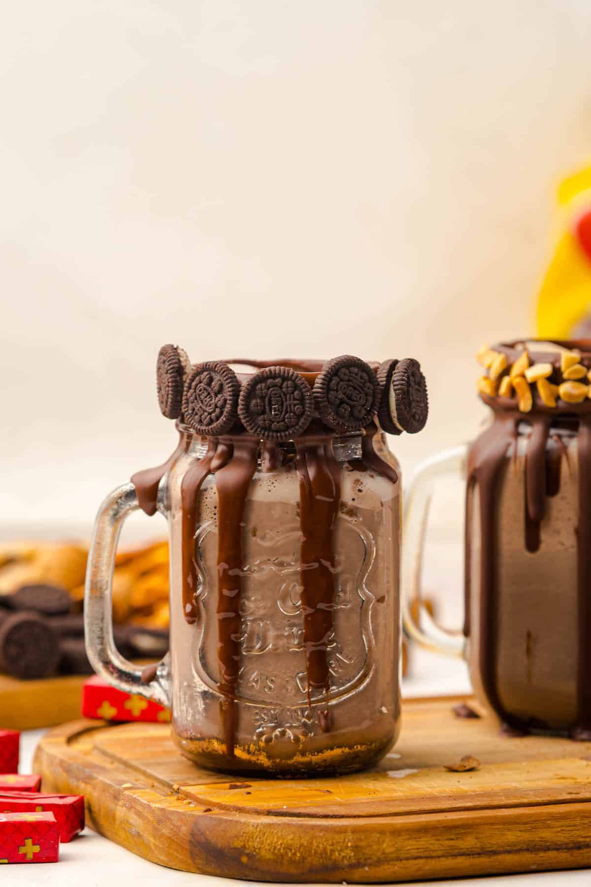 A mason jar of chocolate milkshake topped with mini Oreo cookies and dripping chocolate on the rim&mdash;an irresistible Chocolate Freakshake recipe for any sweet tooth.
