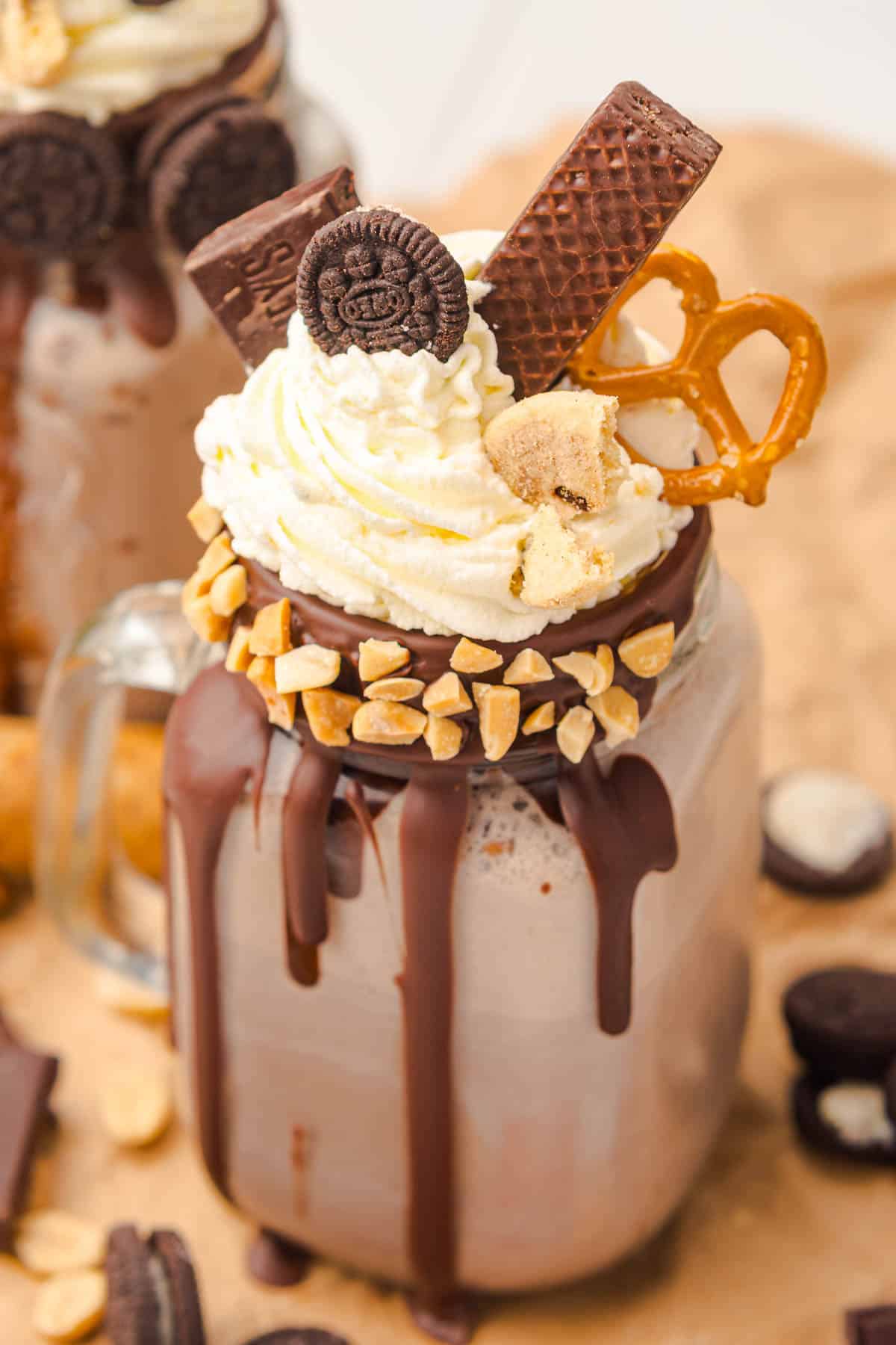 Chocolate Freakshake in a jar topped with whipped cream, cookies, pretzel, nuts, and a rich chocolate drizzle&mdash;a decadent treat inspired by the ultimate Freakshake Recipe.